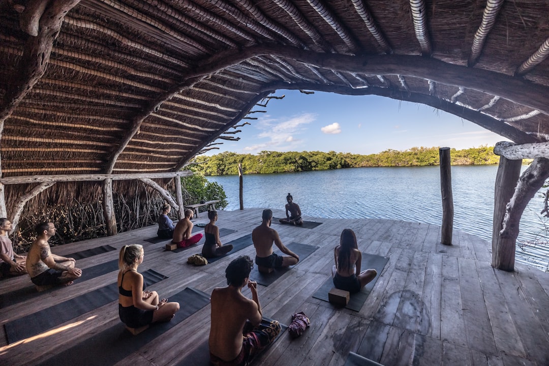 a-group-of-people-sitting-on-top-of-a-wooden-floor-uqcwuxfalww
